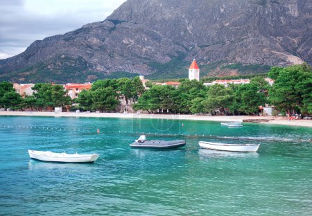 Foto de Barcos en agua de mar turquesa. Playa de arena y paisaje de laguna. Playa pública de Promajna en Croacia - Imagen libre de derechos
