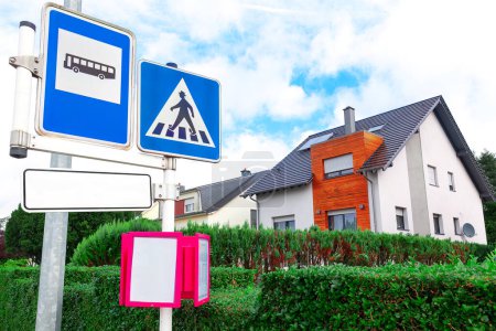 Téléchargez les photos : Panneaux routiers et maisons modernes avec fond bleu ciel. Concept d'immobilier au Luxembourg. Station de bus européenne - en image libre de droit