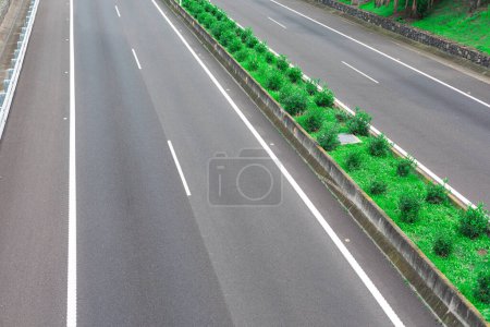 Highway asphalt road separated by grass median strip