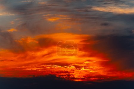 Colorful dramatic sky with cloud at sunset. Sky with fire in clouds at twilight