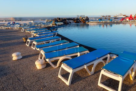 Téléchargez les photos : Chaises longues sur la rive de la station balnéaire. Paysage de vacances d'été - en image libre de droit