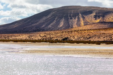 Landscape of Salar de Uyuni Salt Flats, Bolivia. Sandy dunes and lake near mountain 