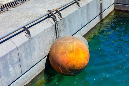 Bola flotante de goma en el puerto para barcos de amarre