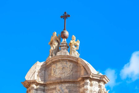 Religious sculptures and cross on the church top 