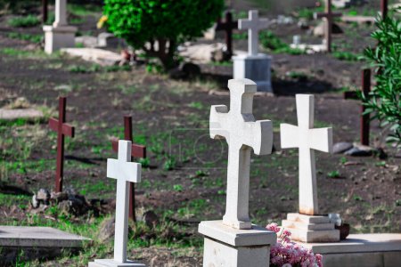 Des croix de pierre parsemant le paysage du cimetière créent une atmosphère respectueuse