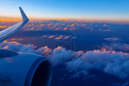 Anmutig schweben Flugzeugtriebwerk und Tragfläche am Abend über Wolken. Kanarische Inseln im Atlantik überfliegen 