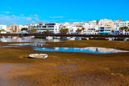 Téléchargez les photos : Bateaux de pêche à marée basse sur la côte atlantique de Lanzarote. Ville d'Arrecife à Lanzarote et lagune à marée basse - en image libre de droit