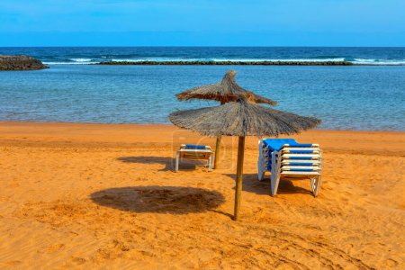 Parasols et chaises longues sur la plage de sable. Atmosphère relaxante vacances d'été