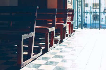 Téléchargez les photos : Chaises dans une rangée sur le sol à l'intérieur de l'église. Bancs en bois pour prier - en image libre de droit