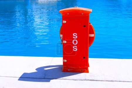 Red lifebuoy on the water edge with text SOS