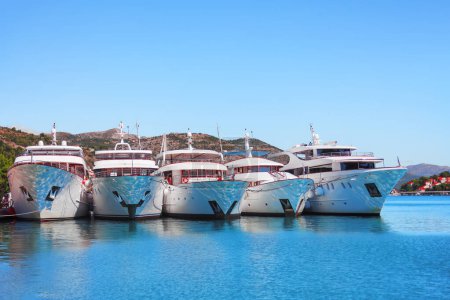 Opulent vessels docked in the harbor. Port of Dubrovnik with expensive yachts