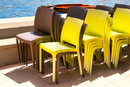 Photo for Plastic chairs arranged in a pile. Seats of coastal terrace - Royalty Free Image