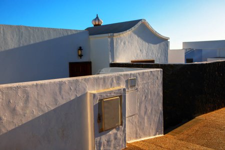 white building with a black wall and a sign address. The building is located in Canary Islands
