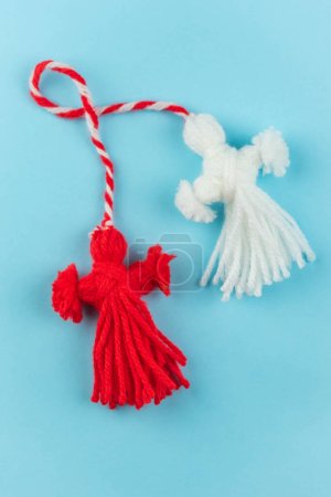 Photo for Traditional Martisor - symbol of holiday 1 March, Martenitsa, Baba Marta, beginning of spring and seasons changing in Romania, Bulgaria, Moldova. Greeting and post card for holidays. Blue background. - Royalty Free Image