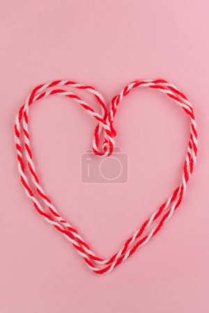 Photo for Traditional Martisor - symbol of holiday 1 March, Martenitsa, Baba Marta, beginning of spring and seasons changing in Romania, Bulgaria, Moldova. Greeting and post card for holidays. Pink background. - Royalty Free Image