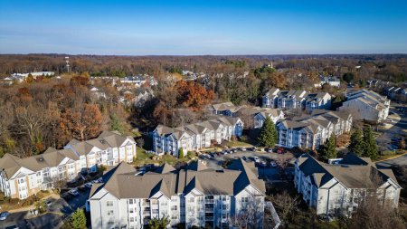 Foto de Drone Aerial Photo of Large Residential Townhome Community on the East Coast of Maryland (en inglés). Complejo de apartamentos de varias unidades con cielo azul profundo y nubes blancas - Imagen libre de derechos