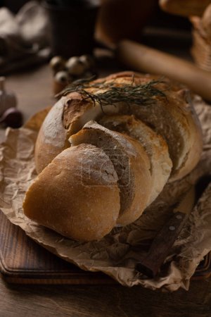 Photo for Sliced bread with knife on wood table. Homemade bread at wooden tabletop as baking concept - Royalty Free Image