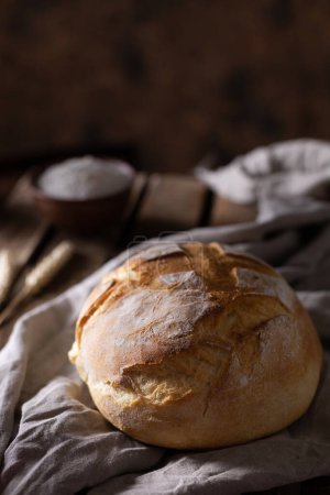 Photo for Fresh bread and table cloth at wooden table. Bakery still life and bread on wood tabletop - Royalty Free Image