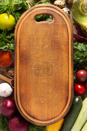 Photo for Variety of fresh vegetables and wood cutting board on table background. Cooking concept and salad ingredients at tabletop top view - Royalty Free Image