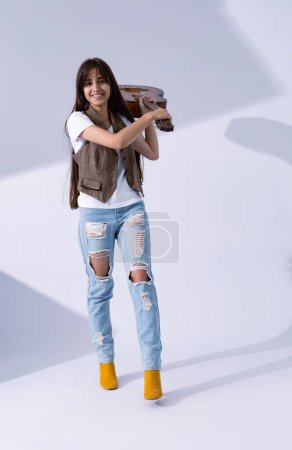 Photo for Young woman hand over acoustic guitar. Musician in life style holding classic guitar - Royalty Free Image