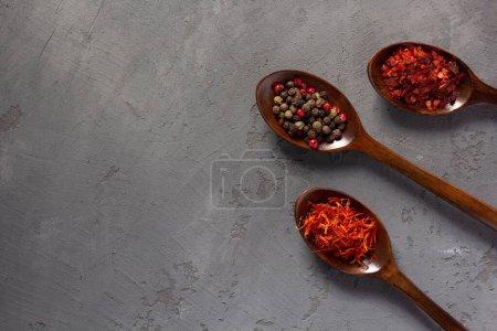 Photo for Variety of spices in spoon on concrete stone table background. Cooking food ingredients at kitchen table top view - Royalty Free Image