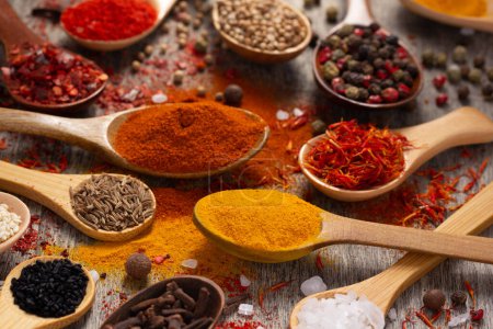 Photo for Variety of spices in spoon on table background. Cooking concept and ingredients at kitchen table closeup - Royalty Free Image