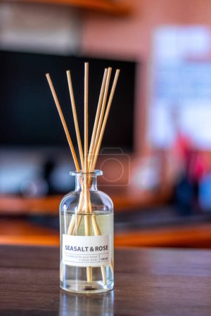 Photo for An aroma diffuser with aromatic oil and sticks in the office near the computer creates an atmosphere of peace and comfort - Royalty Free Image
