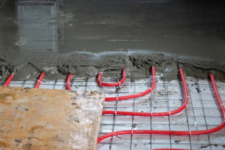 Foto de Instalación de tubos de polipropileno para sistemas de calefacción por suelo radiante, vertiendo el suelo con hormigón - Imagen libre de derechos