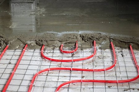 Foto de Instalación de tubos de polipropileno para sistemas de calefacción por suelo radiante, vertiendo el suelo con hormigón - Imagen libre de derechos