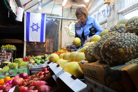 Photo for JERUSALEM - NOV 11 2022:Israeli woman buying fresh fruits in a vegetables store.Israel fruits and vegetables market is projected to grow at a CAGR of 6.1% during the forecast period (2020-2025). - Royalty Free Image