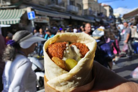 Photo for POV (personal prespective point of view) Person holding a Falafel dish in Laffa (Middle Eastern bread) at Mahane Yehuda Market Jerusalem Israel - Royalty Free Image