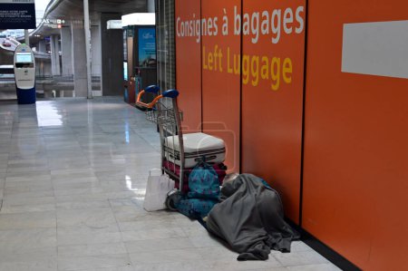 Photo for PARIS - NOV 30 2022:Air passenger sleep at CDG airport in Paris, France.Some people living for long periods of time in airports as they seeking asylum or having difficulty with visas and passports. - Royalty Free Image