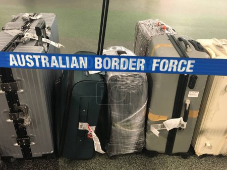 Photo for BRISBANE - DEC 02 2022:Luggage behind Australian border force lines. The federal law enforcement agency responsible for border control enforcement, compliance and detention in Australia. - Royalty Free Image