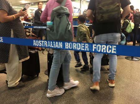 Téléchargez les photos : BRISBANE - DEC 02 2022 : Passagers traversant les lignes des forces frontalières australiennes. L'organisme fédéral d'application de la loi chargé du contrôle des frontières, de la conformité et de la détention en Australie. - en image libre de droit