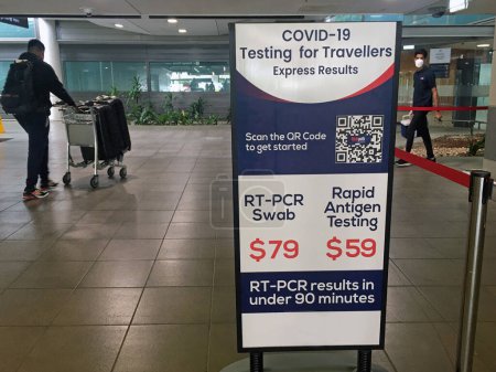 Photo for BRISBANE - DEC 02 2022:Passengers passing by COVID -19 PCR swab test sign in Brisbane Airport. Australian people no longer  need a negative COVID-19 test to leave Australia since 18 April 2022. - Royalty Free Image