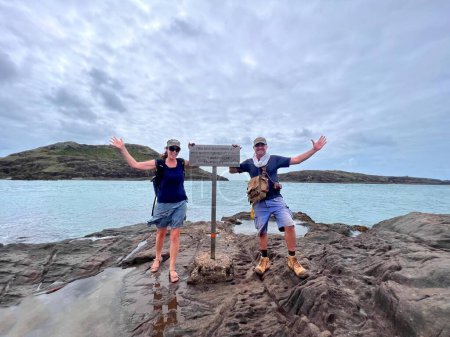 Photo for Happy Australian couple stand at the Northernmost Point of the Australian Continent located at the top of Cape York peninsula in Queensland, Australia. - Royalty Free Image