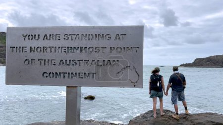 Photo for Australian couple stand at the Northernmost Point of the Australian Continent located at the top of Cape York peninsula in Queensland, Australia. - Royalty Free Image