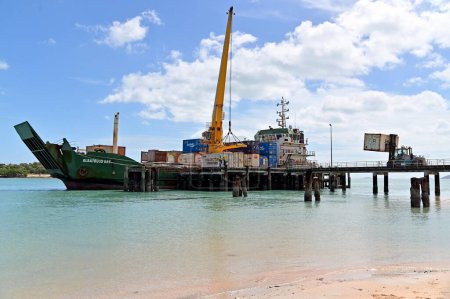 Photo for SEISIA, QLD - JUNE 16 2023:Sea Swift ship loading cargo at Seisia wharf.Sea Swift delivers scheduled freight and cargo services in Queensland through the Torres Strait and Cape York Peninsula. - Royalty Free Image
