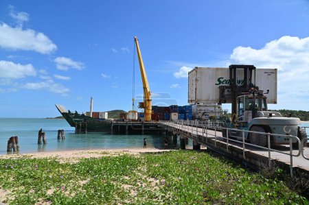 Photo for SEISIA, QLD - JUNE 16 2023:Sea Swift ship loading cargo at Seisia wharf.Sea Swift delivers scheduled freight and cargo services in Queensland through the Torres Strait and Cape York Peninsula. - Royalty Free Image