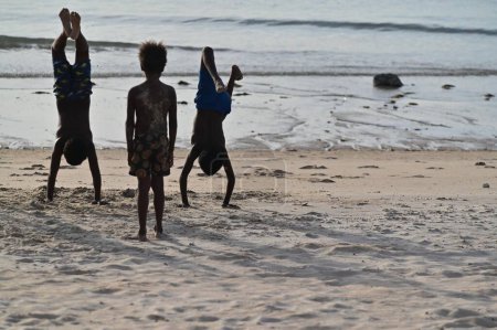 Photo for SEISIA, QLD - JUNE 16 2023:Torres Strait Islanders playing on the beach.They are the Indigenous Melanesian people of the Torres Strait Islands, which are part of the state of Queensland, Australia. - Royalty Free Image