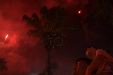 Photo for BRISBANE - FEB 10 2024:Asian Australians family watching fireworks display on lunar new year celebrations.Lunar New Year is the beginning of the new year based on the lunar calendar or lunisolar calendar. - Royalty Free Image