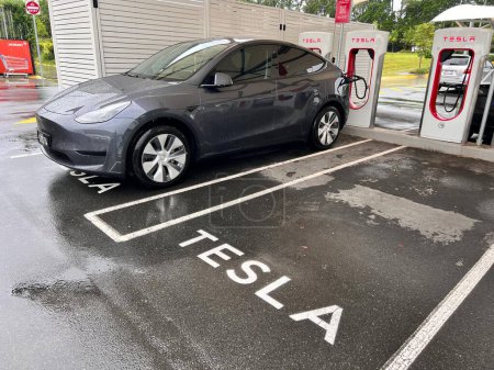 Photo for BRISBANE - FEB 16 2024:Tesla vehicle in Supercharger station.US electric vehicle (EV) giant Tesla has predicted its rapid sales rate growth won't continue in 2024 following a significant drop in 2023 - Royalty Free Image
