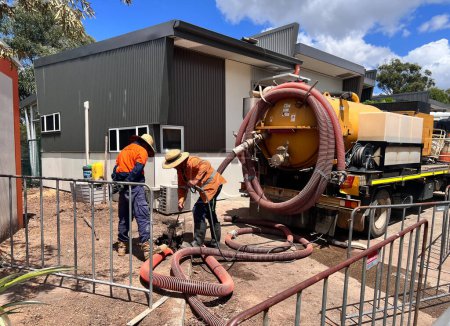 Photo for BRISBANE - JAN 28 2024:Sewage pumping service workers use a vacuum truck to empty septic tanks. Some systems require pumping every few years while others may be able to go 1020 years between pumping. - Royalty Free Image
