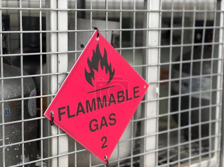 Photo for BRISBANE - NOV 08 2023:Red Flammable gas sign on gas cylinders cage.48% of Australians use gas cooktop for cooking at home and 7% of Australians use unflued gas heaters regularly during cooler months - Royalty Free Image