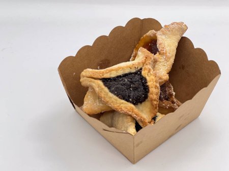 Téléchargez les photos : Pourim cookies de vacances juifs soutenu Hamentashen Ozen Haman dans une boîte cadeau fermer fond alimentaire. - en image libre de droit