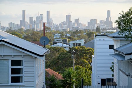 Photo for BRISBANE - NOV 13 2023:Residential houses against Brisbane City skyline.Home prices across Australia have hit new highs, with the median value of a home in a capital city shooting to $832,000. - Royalty Free Image