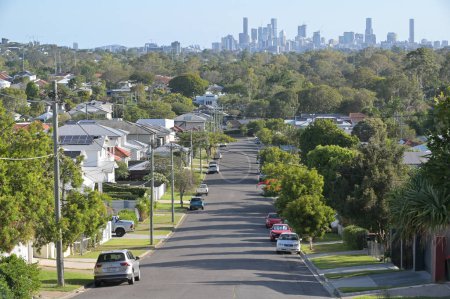 Photo for BRISBANE - NOV 18 2023:Residential houses street against Brisbane City skyline.Home prices across Australia have hit new highs, with the median value of a home in a capital city shooting to $832,000. - Royalty Free Image