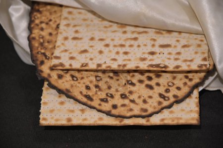Photo for Matzah Unleavened flatbread on seder table on Passover Jewish holiday.Matzah unleavened flatbread symbolizes redemption and freedom, but it is also called lechem oni in Hebrew poor man's bread. - Royalty Free Image