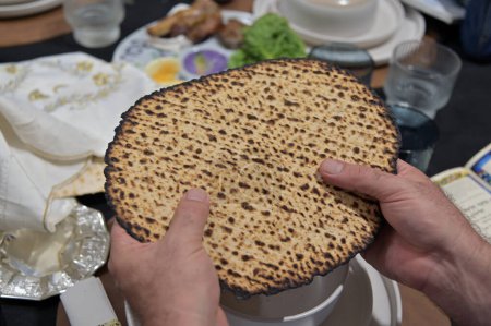 Photo for Jewish man hold handmade shmura matzo unleavened flatbread used at the Passover Seder especially for the mitzvot of eating matzo and afikoman on Passover Jewish Holiday. - Royalty Free Image