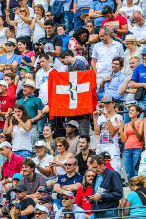 Foto de PARIS, FRANCE - MAY 27, 2015: Swiss tennis fans support seventeen times Grand Slam champion Roger Federer during his first round match at Roland Garros 2015 in Paris, France - Imagen libre de derechos